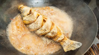 Kahverengi soslu Snapper Fish demir tavada kaynıyor