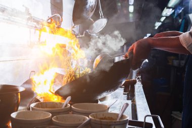 Şef mutfakta kızartma yapıyor.