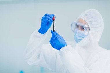 Doktor laboratuvar odasında hastanın kan damarlarını test etti.