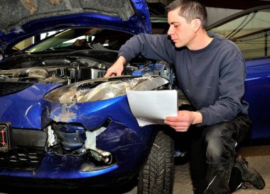 Hasarlı araçta çalışan sigorta uzmanı.