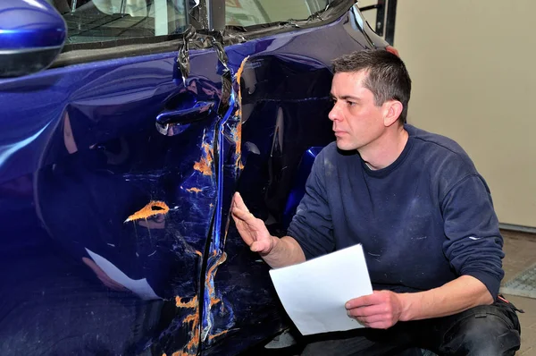Ekspert ubezpieczeniowy pracujący w uszkodzonym samochodzie. — Zdjęcie stockowe