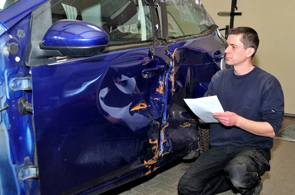 Versicherungsexperte arbeitet an beschädigtem Auto. — Stockfoto