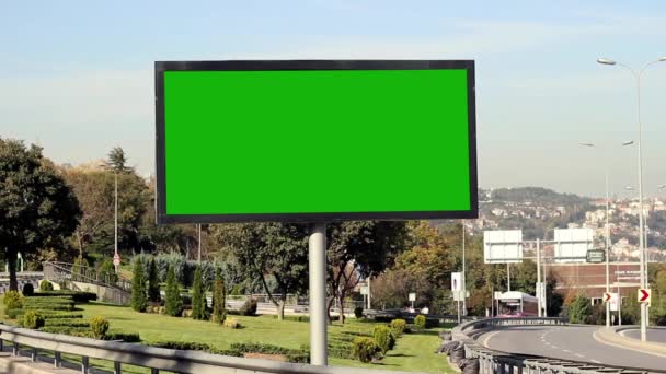 Reclame billboard groen scherm aan de zijlijn van de snelweg met verkeer — Stockvideo