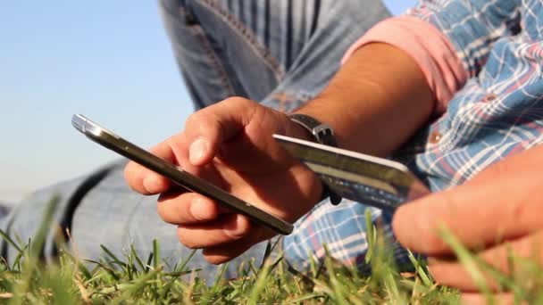 Młody mężczyzna zakupy online z karty kredytowej i smartphone — Wideo stockowe