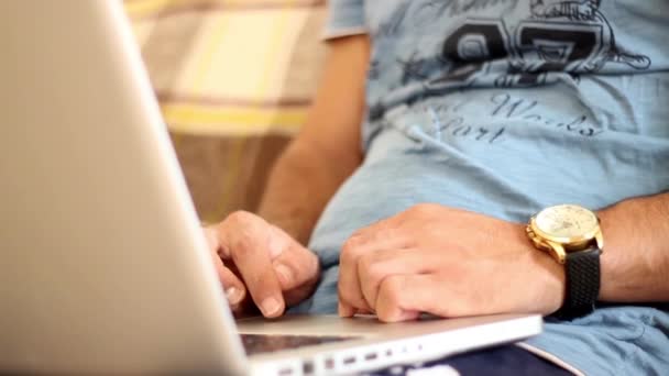 Joven masculino independiente trabajando desde casa a través del ordenador portátil, Close-up de manos masculinas escribiendo en computadora — Vídeo de stock