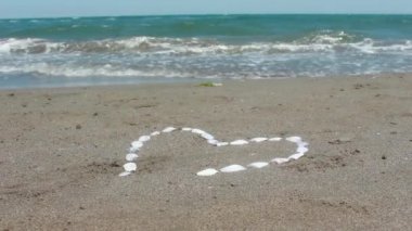 Köpüklü Dalga yıkar üzerinde taş çakıl kum kalbinde