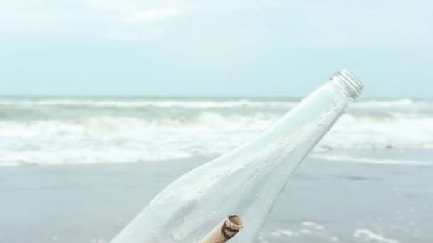 Νεαρός άνδρας άνοιγμα μήνυμα σε ένα μπουκάλι σε παραλία με άμμο — Αρχείο Βίντεο