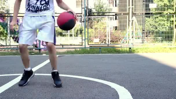 Młody człowiek gra w koszykówkę — Wideo stockowe