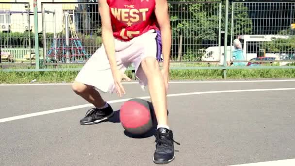 Młody człowiek gra w koszykówkę — Wideo stockowe