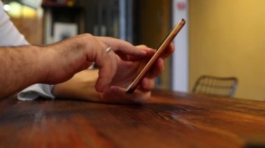 restoranda cep telefonu kullanan adam