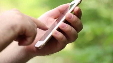 Bir ormanda bir telefona yazma erkek genç