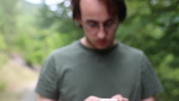 Adolescente masculino escribiendo en un teléfono — Vídeos de Stock