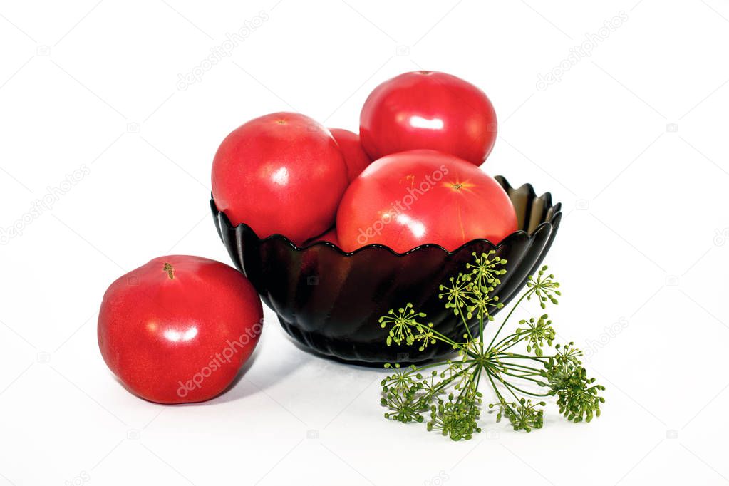 Red tomatoes in a black plate on a white background
