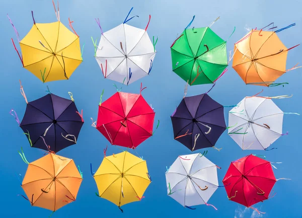 Mavi gökyüzü rüzgar gelişmekte şeritler ile çok renkli şemsiyeler