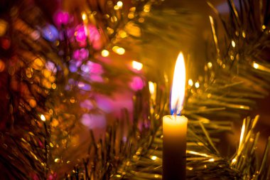 Yanan bir mum bir yılbaşı ağacı ve bokeh etkisi ile parlak aydınlatma fon karşı.