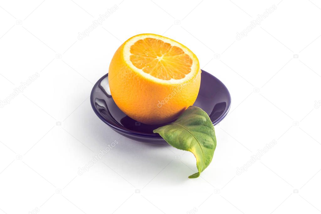 Sliced orange in a black plate on a white background