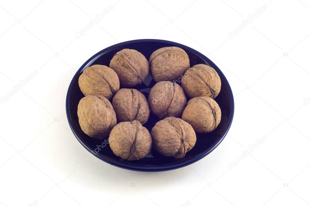 Nuts in a black plate on a white background