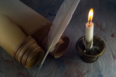 Eski ilerleyin, tüy kalem, karanlık bir odada yanan bir mum şamdan