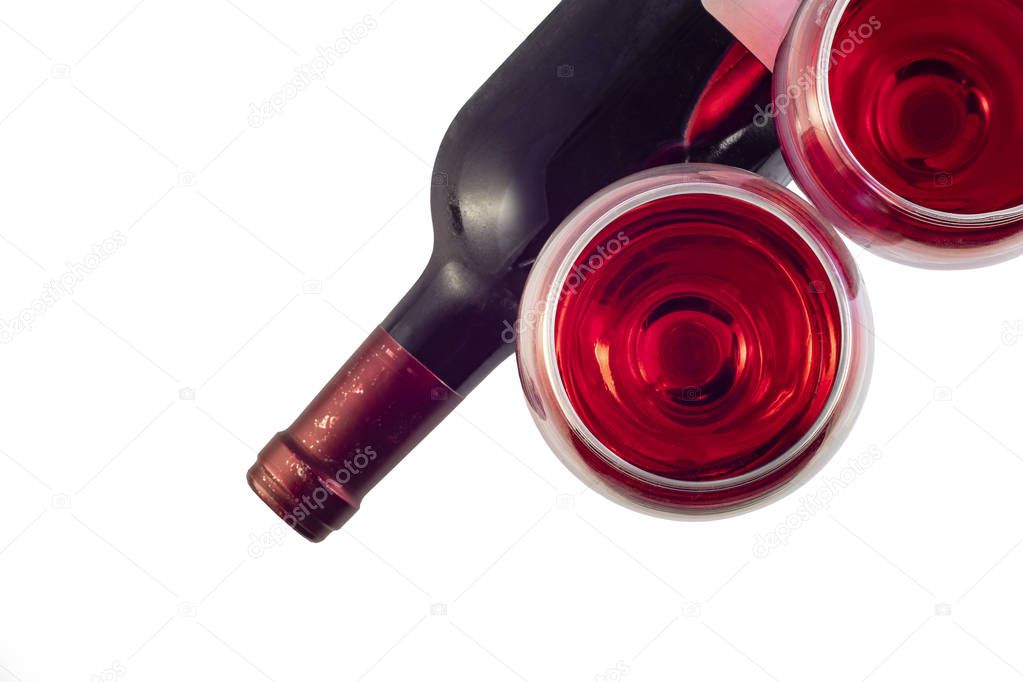 Two glasses with red wine and a bottle of wine on a white background. Top view