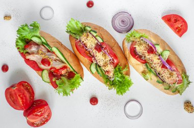 Sosisli sandviç, sosis, peynir ve sebzeler beyaz arka planda. Yukarıdan görüntüle.