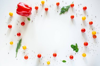 Biber, kiraz domatesleri sarı ve kırmızı, baharatlar beyaz arka planda. Yukarıdan bak. Boşluğu kopyala.