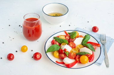 Peynirli ve fesleğenli yaz sebze salatası. Bardakta sos ve domates suyu..