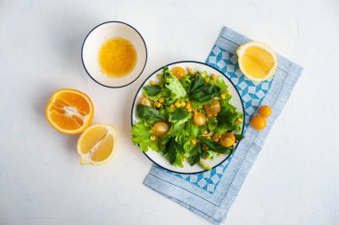 Sarı sebzeli hafif vejeteryan salatası ve narenciye soslu yeşillikler. Yukarıdan görüntüle.