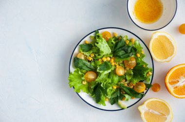 Sarı sebzeli hafif vejeteryan salatası ve narenciye soslu yeşillikler. Yukarıdan görüntüle.