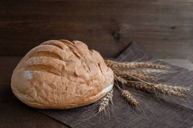 Tahta zemin üzerinde çıtır çıtır ekmek ve buğday kulaklı taze ekmek..