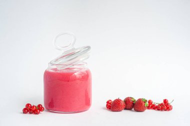 Beyaz arka planda reçelli çilek ve kırmızı frenk üzümü..