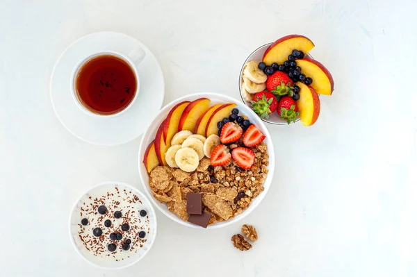 Desayuno de verano con granola, té, yogur y bayas sobre un fondo claro. Flatly. . —  Fotos de Stock