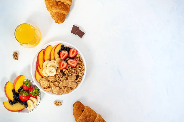 Étrendi nyári reggeli müzli gyümölcsökkel, bogyókkal, gyümölcslével és croissant világos alapon. Simán.. — Stock Fotó