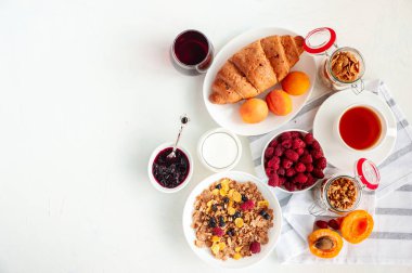 Müsli, süt, meyve suyu, kayısı ve ahududulu hafif bir yaz kahvaltısı.