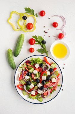 Beyaz beton arka planda bir tabak Yunan salatası. Peynirli sebze salatası..