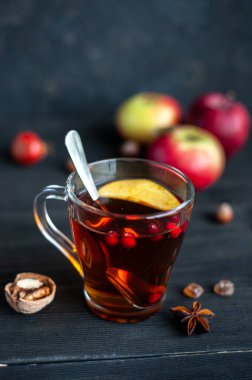 Sonbahar çayı, böğürtlen ve elmalarla siyah ahşap arka planda.. 