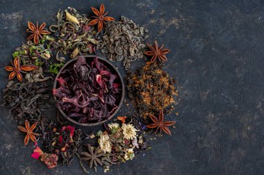 Koyu arkaplandaki farklı çay türlerinden kompozisyon. Metin için bir yer.