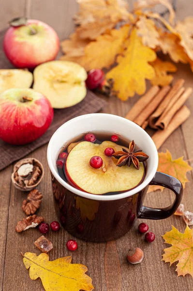 Baharatlı, böğürtlenli ve elmalı, ahşap arka planda ılık sonbahar çayı. Dikey fotoğraf.