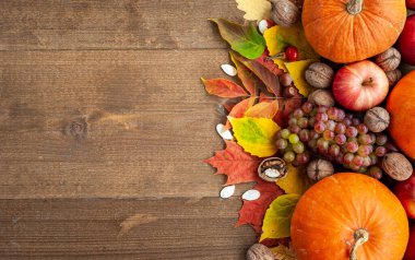 Şükran Günü. Hasat et. Sonbahar meyveleri, sebzeler, fındıklar ve kahverengi ahşap arka plandaki yaprakların bileşimi. Yukarıdan bak. Metin için bir yer.