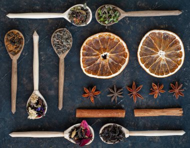 Tahta kaşıklar, anason, tarçın ve kurutulmuş portakallı çayın değişik çeşitleri. Düğümleniyor.