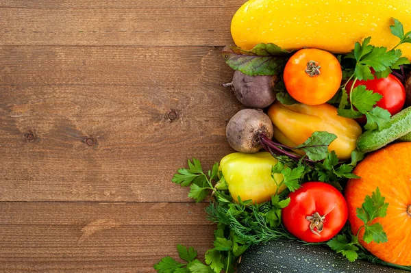 Cosecha. Verduras de otoño sobre un fondo de madera. Comida vegana. El diseño es una vista superior. Banner. — Foto de Stock