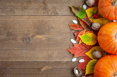 Şükran Günü. Hasat et. Sonbahar meyveleri, sebzeler, fındıklar ve kahverengi ahşap arka plandaki yaprakların bileşimi. Yukarıdan bak. Metin için bir yer.