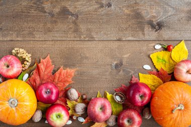 Şükran Günü. Hasat et. Sonbahar meyveleri, sebzeler, fındıklar ve kahverengi ahşap arka plandaki yaprakların bileşimi. Yukarıdan bak. Metin için bir yer.