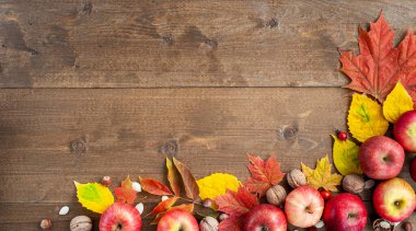 Şükran Günü. Hasat et. Sonbahar meyveleri, sebzeler, fındıklar ve kahverengi ahşap arka plandaki yaprakların bileşimi. Yukarıdan bak. Metin için bir yer.