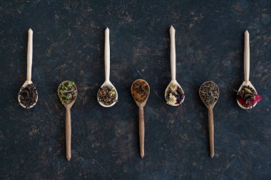 Koyu arkaplandaki farklı çay türlerinden kompozisyon.