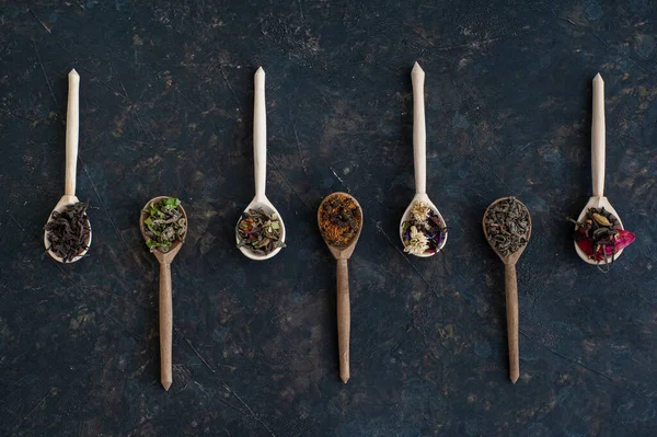 Koyu arkaplandaki farklı çay türlerinden kompozisyon.