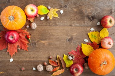 Şükran Günü. Hasat et. Sonbahar meyveleri, sebzeler, fındıklar ve kahverengi ahşap arka plandaki yaprakların bileşimi. Yukarıdan bak. Metin için bir yer.