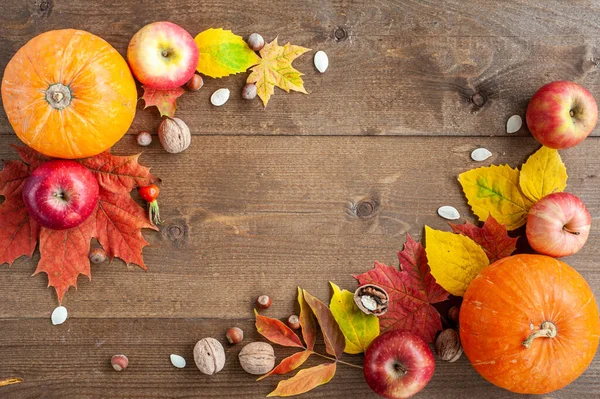 Şükran Günü. Hasat et. Sonbahar meyveleri, sebzeler, fındıklar ve kahverengi ahşap arka plandaki yaprakların bileşimi. Yukarıdan bak. Metin için bir yer.