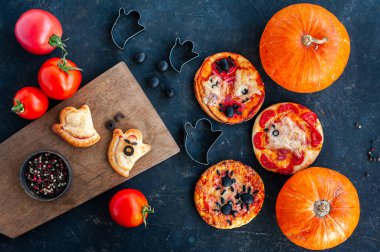 Cadılar Bayramı yemeği. Cadılar Bayramı 'nda hayaletler ve örümceklerle mini pizza. Kabak, zeytin ve domatesli kompozisyon.