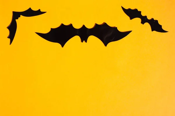 Lo sfondo per Halloween. Su uno sfondo arancione sono ragni neri e pipistrelli. Un posto per il testo. — Foto Stock