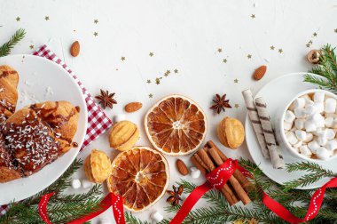 Noel kahvaltısı. Noel sabahı. Dekore edilmiş bir Noel ağacı dalına sahip açık beton bir arka planda marşmelov ve kruvasanla bir fincan kakao. Yukarıdan görüntüle.